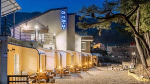 a building with tables and chairs in front of it at Samcheok ara Pension in Samcheok