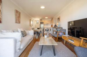 a living room with a couch and a table at Seaspray Views - Lifestyle Yamba in Yamba