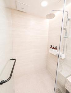 a shower with a glass door in a bathroom at 플럼바고올스위트34 in Chosan-ni