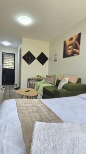 a bedroom with a bed and a couch and a table at Luna homes in Ruaka