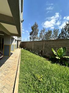 a grassy yard next to a brick wall at Luna homes in Ruaka
