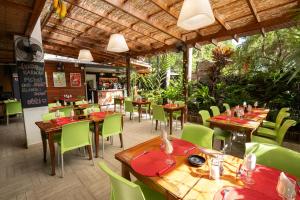 a restaurant with wooden tables and green chairs at Hôtel du Centre Appart hôtel Business avec Parking Gratuit à Nouméa in Noumea