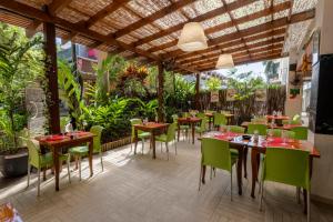 a restaurant with wooden tables and green chairs at Hôtel du Centre Appart hôtel Business avec Parking Gratuit à Nouméa in Noumea