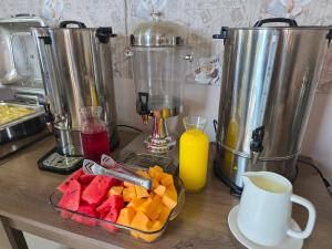 a table with a bowl of fruit and some juice at Wave-ტალღა in Kobuleti
