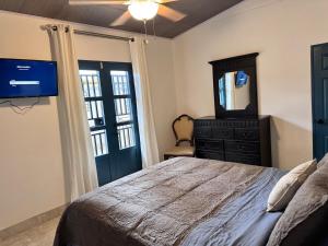 a bedroom with a bed and a dresser and a mirror at Casa Dulce in Estelí
