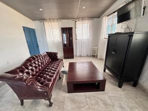 a living room with a leather couch and a coffee table at Casa Dulce in Estelí