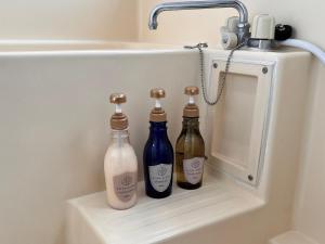 three bottles sitting on a shelf under a bathroom sink at 伊豆ビーチクラブ in Shimoda