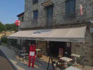 a store with tables and chairs in front of a building at Auberge du sichon in Ferrières-sur-Sichon