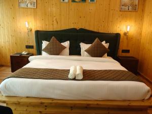 a bedroom with a large bed with two white towels at Cottages & Cafe in Dogadda