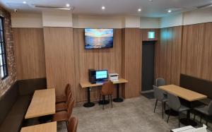 a waiting room with tables and a computer on the wall at Brown Dot Hotel Guun in Suwon