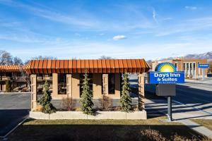 a day inn and suites sign in front of a building at Days Inn & Suites by Wyndham Logan in Logan