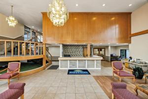 a living room with a staircase and a lobby at Days Inn & Suites by Wyndham Logan in Logan