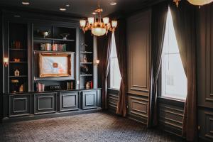 a room with black walls and windows with a chandelier at The Driskill in Austin