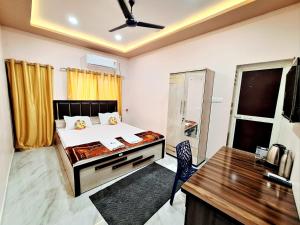 a bedroom with a bed and a desk in it at Mona Homestay in Sambalpur
