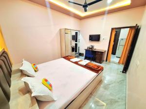 a bedroom with a large white bed with two pillows at Mona Homestay in Sambalpur