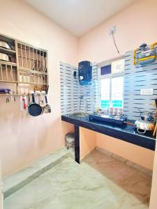 a kitchen with a counter with a sink and a window at Mona Homestay in Sambalpur +13 photos