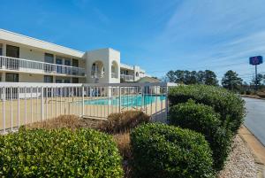 una piscina frente a un edificio con arbustos en Motel 6-Newnan, GA, en Newnan