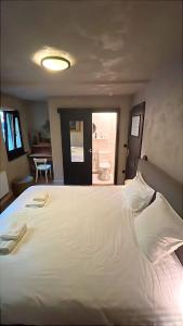 a bedroom with a large white bed and a bathroom at LaVue - Forest Twin Rooms in La-Roche-en-Ardenne