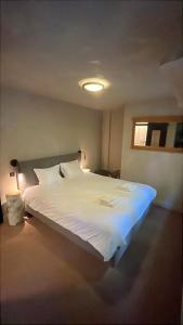 a bedroom with a white bed with a light on it at LaVue - Forest Twin Rooms in La-Roche-en-Ardenne
