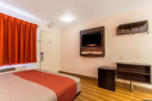 a hotel room with a bed and a flat screen tv at Motel 6-Garland, TX - Dallas in Garland