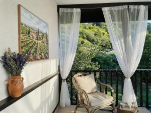 a chair sitting on a balcony with a window at Kassandrova Guest House & Spa in Bratsigovo