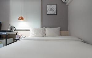 a bedroom with a large white bed in a room at Hotel AMY in Incheon