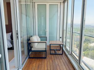 a room with glass windows and a table on a balcony at Boutique Hotel 19D in Almaty