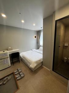 a bedroom with a bed and a desk and a mirror at Mega Stay Dongdaemun in Seoul