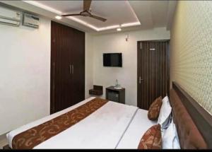 a bedroom with a large bed and a flat screen tv at Hotel CP Residency in Agra +17 photos