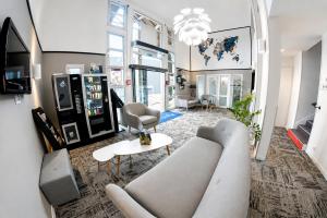 a living room with a couch and a table at Kyriad Hôtel La Fleche in La Flèche