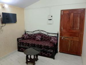 a room with a couch and a door and a stool at Cabo De Rama Cottage in Cola
