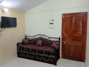 a room with a couch and a wooden door at Cabo De Rama Cottage in Cola