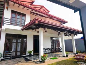 a house with awning and chairs on a patio at Dishan Green Retreat in Ambalangoda