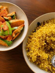 two bowls of food with rice and vegetables on a table at Homestead thapli in Pinjaur +5 photos