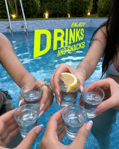 a group of people holding glasses of water in a pool at Homestead thapli in Pinjaur