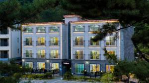a large white building with lights on at Samcheok The Ggeullim Pension in Samcheok