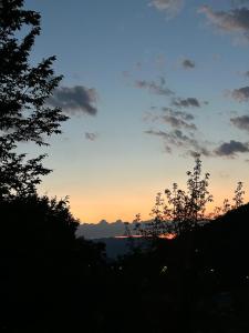 a sunset in the sky with trees in the foreground at Hegyi-lak vendégház in Praid