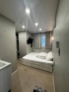 a bedroom with a bed and a window and shoes at Mega Stay Dongdaemun in Seoul