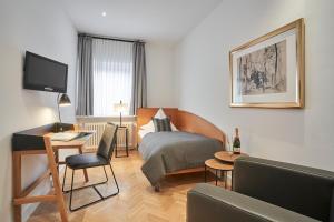 a hotel room with a bed and a desk at Hotel Goldener Engel in Speyer