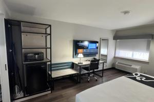 a room with a desk with a computer and a tv at La Quinta Inn by Wyndham Auburn Worcester in Auburn