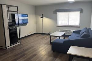 a living room with a blue couch and a tv at La Quinta Inn by Wyndham Auburn Worcester in Auburn