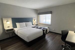 a hotel room with a large bed and a window at La Quinta Inn by Wyndham Auburn Worcester in Auburn +24 photos