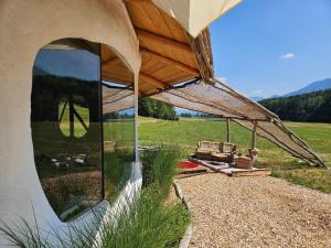 a pavilion with a chair and a couch under a roof at EinBaumHaus Wörthersee in Auen +14 photos