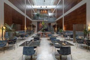 a restaurant with tables and chairs and a staircase at DoubleTree by Hilton Turin Lingotto in Turin