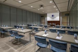 a conference room with tables and chairs and a podium at DoubleTree by Hilton Turin Lingotto in Turin