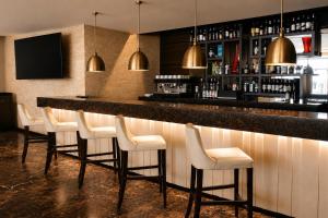 a bar with a row of white bar stools at DoubleTree by Hilton Nairobi in Nairobi