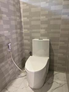 a bathroom with a white toilet in a room at Garden Breeze in Bwejuu