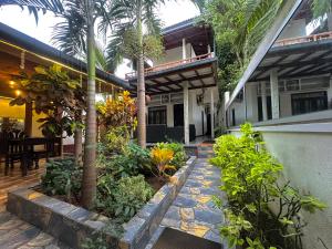 a courtyard of a building with palm trees and plants at Rekawa Turtle Gate Hotel in Tangalle