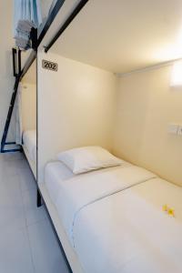 a small room with a white bed in it at V Canggu Dormitory in Canggu