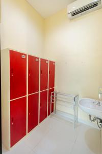 a bathroom with red lockers and a sink at V Canggu Dormitory in Canggu